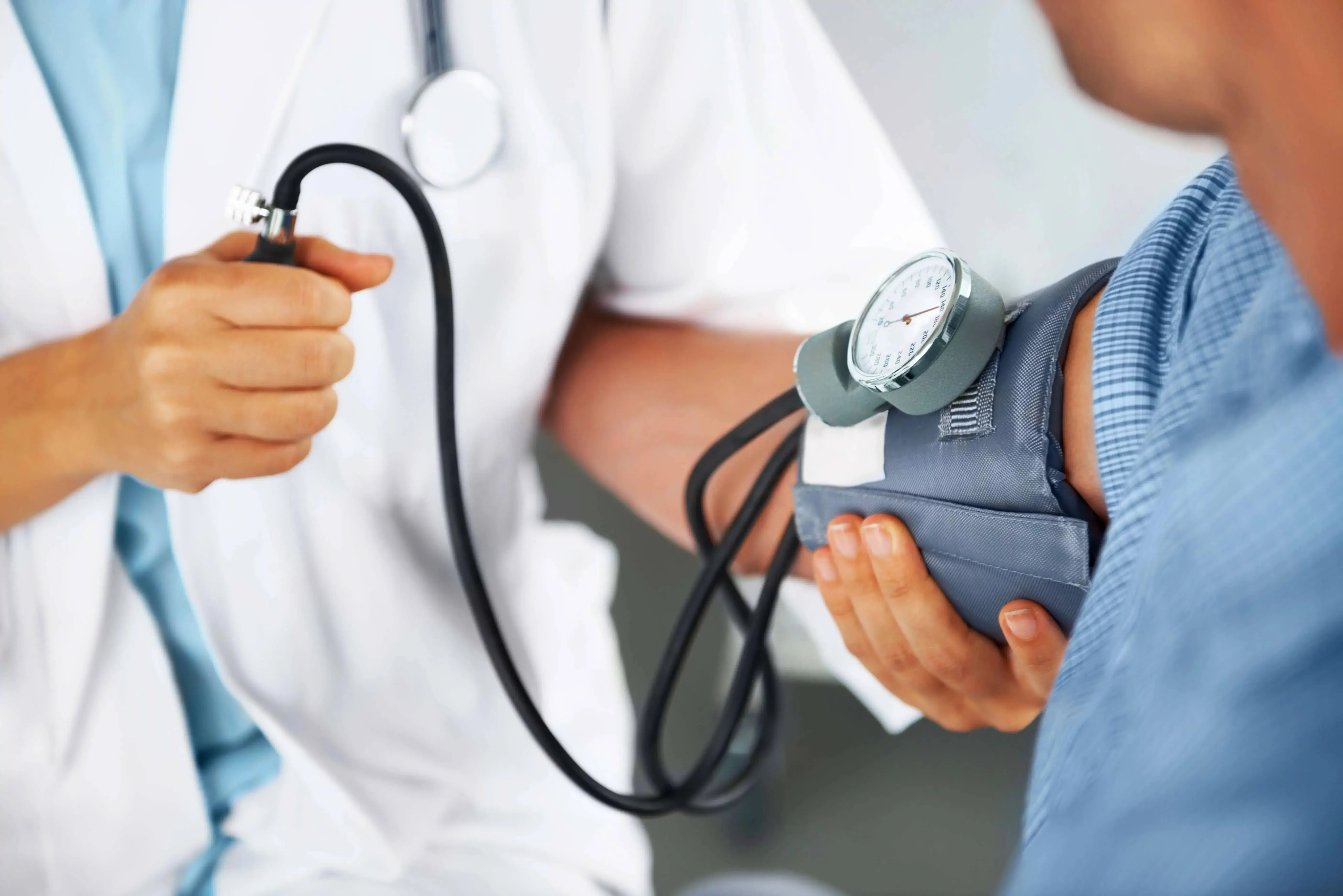 Doctor taking blood pressure on patient.